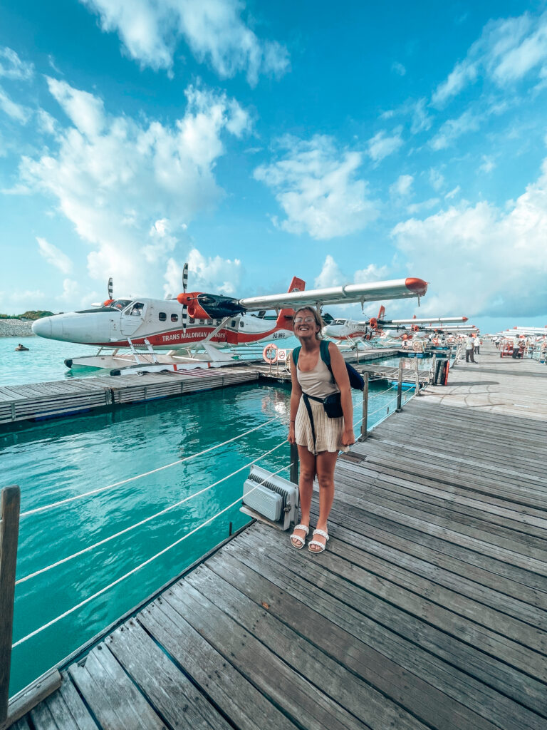 Girl standing in front of sea plane maldives